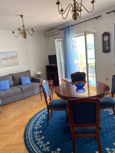 sala de estar con mesa de madera y sillas en Apartments Grifone Lux, en Herceg-Novi