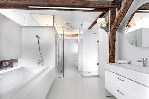 y baño blanco con lavabo y ducha. en Apartamenty Pomarańczarnia, en Poznan