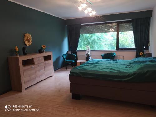 ein Schlafzimmer mit einem Bett, einem Fenster und einer Kommode in der Unterkunft Park Villa Ferienwohnung mit Pool und 3 Schlafzimmer in Uelzen