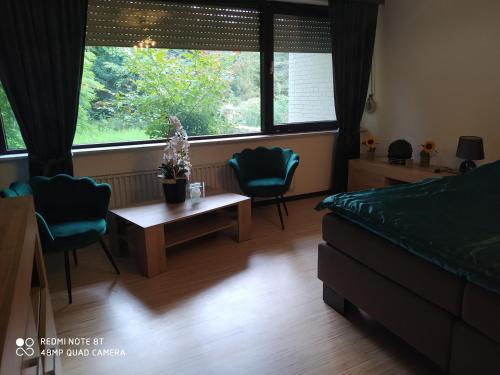 Schlafzimmer mit einem Bett, einem Tisch und Stühlen in der Unterkunft Park Villa Ferienwohnung mit Pool und 3 Schlafzimmer in Uelzen