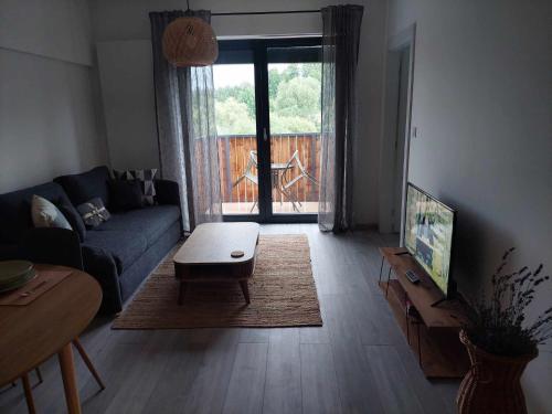 een woonkamer met een bank en een salontafel bij Apartmán Bešeň 304 in Bešeňová