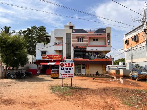 ein Gebäude mit einem Schild davor in der Unterkunft ASSHAPPYSTAYINN HOTEL in Tiruchchirāppalli