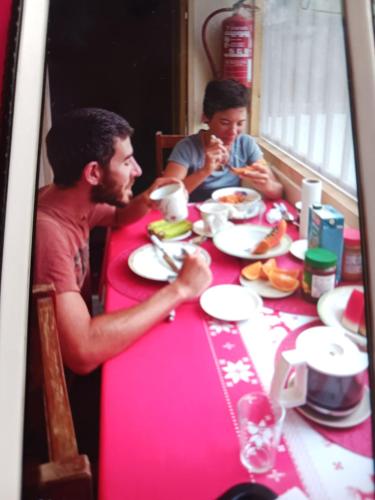 twee mensen aan een tafel eten bij Casa de Férias in Tarrafal