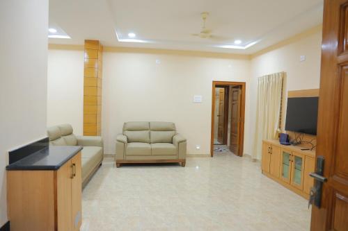 un soggiorno con divano e TV di Padma Homes Stay- Luxury Service Apartment 1BHK & 2BHK & 3BHK a Tirupati