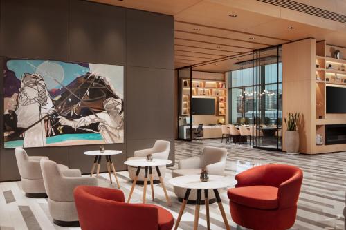 een lobby met tafels en stoelen en een groot schilderij aan de muur bij Four Points by Sheraton Istanbul Kagithane in Istanbul