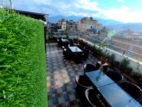 une rangée de tables et de chaises sur un balcon dans l'établissement Hotel Simal, à Katmandou