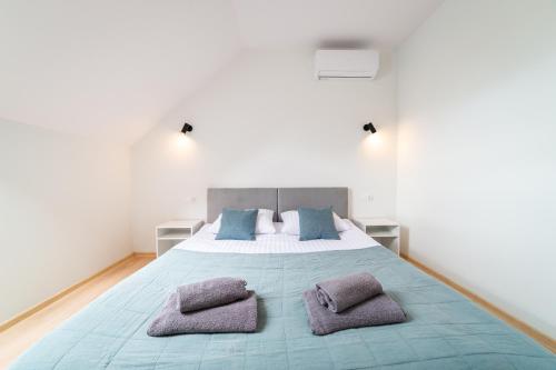 um quarto com uma cama grande com duas almofadas em Apartamenty Literówka em Mikołajki