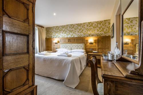 een slaapkamer met een bed en een bureau en een bed sidx sidx sidx bij Yewfield Vegetarian Guest house in Ambleside