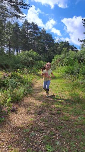 uma menina correndo por um caminho em um campo em GF Studio, Secure parking, outside area, cinema(S) em Hurn