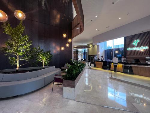 eine Lobby eines Hotels mit Pflanzen und einer Bar in der Unterkunft Holiday Inn Bogota Airport, an IHG Hotel in Bogotá