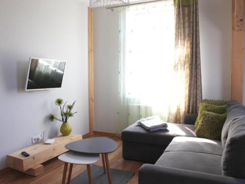 a living room with a couch and a table at Apartamenti Starp Krastiem 2 in Liepāja