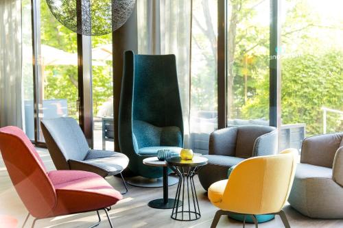 Habitación con sillas y mesa frente a una ventana en Motel One Wien-Prater, en Viena