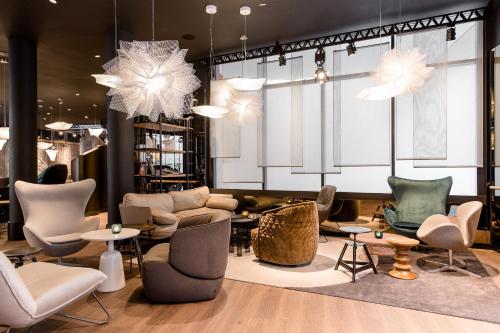 a lobby with chairs and tables in a store at Motel One Stuttgart-Mitte in Stuttgart