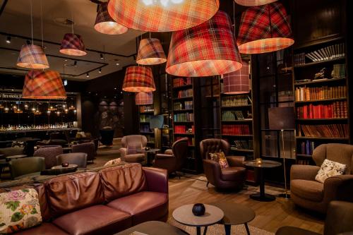 una biblioteca con sofás, sillas y libros en Motel One Manchester-St. Peter´s Square, en Mánchester