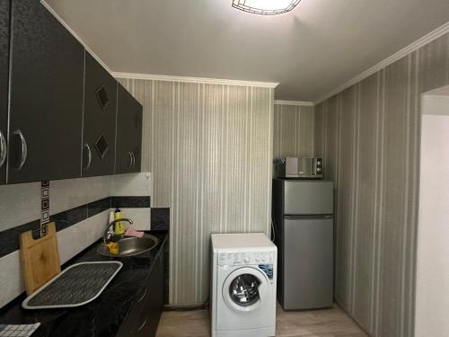 (( Turksib ))One-room apartment opposite Almaty Airport的小厨房配有洗衣机。