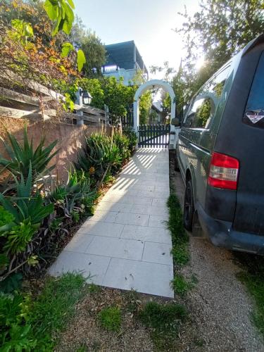 a car parked next to a sidewalk next to a fence at PortoPollo SurfHouse in Barrabisa