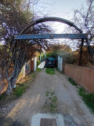 an archway over a road with a car parked under it at PortoPollo SurfHouse in Barrabisa