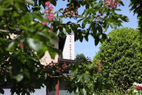 een wit bord bovenop een gebouw met bomen bij Haus Rebland Urlaubsglück-Hotel in Baden-Baden