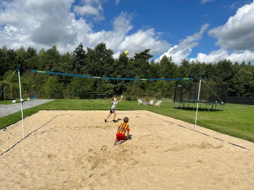 due bambini che giocano a pallavolo su una rete da pallavolo di Sun House a Wręcza