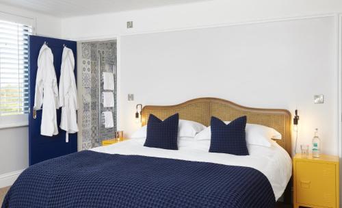 een slaapkamer met een blauw en wit bed met blauwe kussens bij The Jolly Sportsman in Lewes