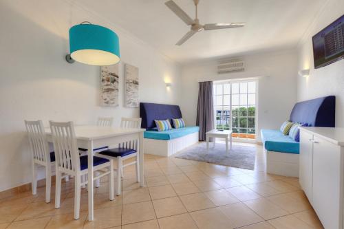 een keuken en een woonkamer met een tafel en stoelen bij 3HB Clube Humbria - All Inclusive in Albufeira