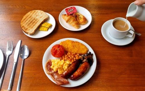 una mesa con platos de desayuno y una taza de café en The Management Centre, en Bangor