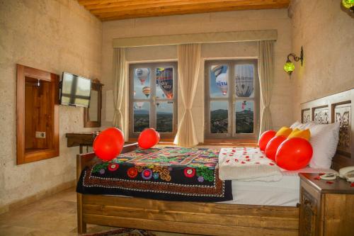 ein Schlafzimmer mit einem Bett mit roten Ballons darauf in der Unterkunft My Story Cave Hotel in Uchisar