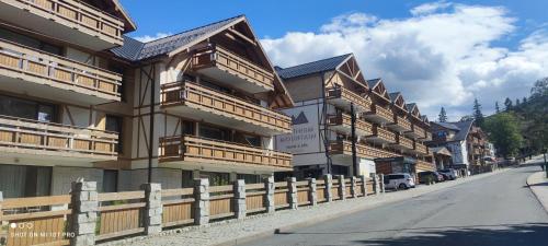 a building with wooden balconies on the side of a street at APARTAMENT w PLATINUM MOUNTAIN in Szklarska Poręba