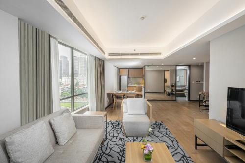 uma sala de estar com um sofá e uma televisão em Riverdale Residence Xintiandi Shanghai em Xangai