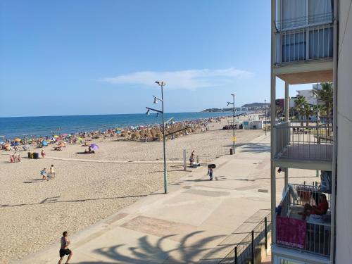 a beach with a crowd of people on it at A pie de PLAYA in La Pineda