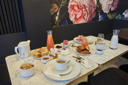 un tavolo con prodotti per la colazione e caffè di Hôtel Beauquartier Montmartre a Parigi