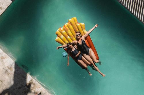 two women laying on a raft in the water at El Refugio Ski & Summer Lodge in San Martín de los Andes