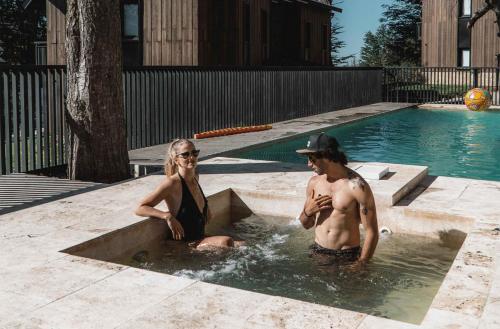 a man and a woman sitting in a pool at El Refugio Ski & Summer Lodge in San Martín de los Andes