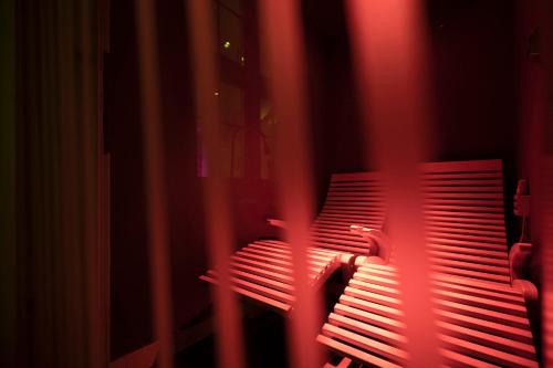 a red light shining on a bench in a room at Hotel Acadia - Adults Mountain Home in Selva di Val Gardena