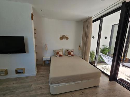 1 dormitorio con 1 cama y TV de pantalla plana en The Singular - Downtown Studio, en Faro