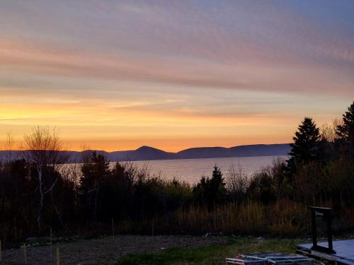 zachód słońca nad jeziorem z górami w oddali w obiekcie Moceanset Getaways-Beautiful Ocean, Mountain & Sunset Views, "Camping Experience" w mieście Dingwall