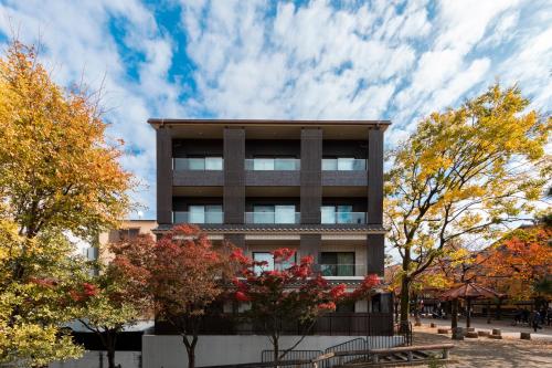 un edificio con alberi autunnali di fronte ad esso di Hotel Alza Kyoto a Kyoto