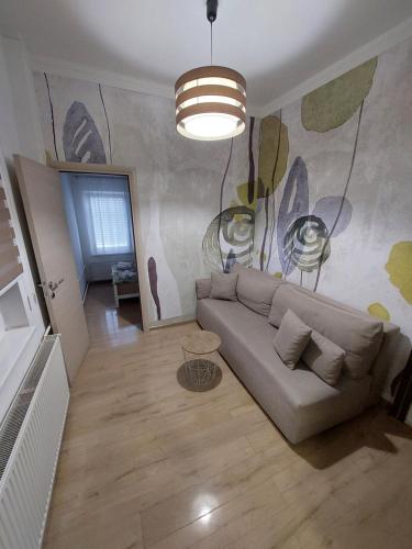 een woonkamer met een bank en een schilderij aan de muur bij Ancora apartment Anja in Novi Sad