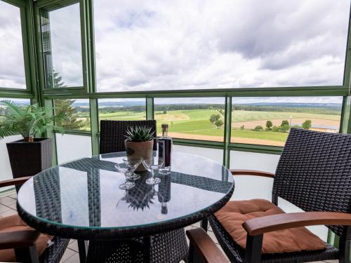 een glazen tafel en stoelen op een balkon met uitzicht bij Apartment Schönblick - F 55 by Interhome in Dittishausen