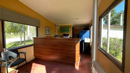 una oficina con un bar con una silla y ventanas en Cabañas Huallilemu Norte - Caja Los Andes, en El Quisco