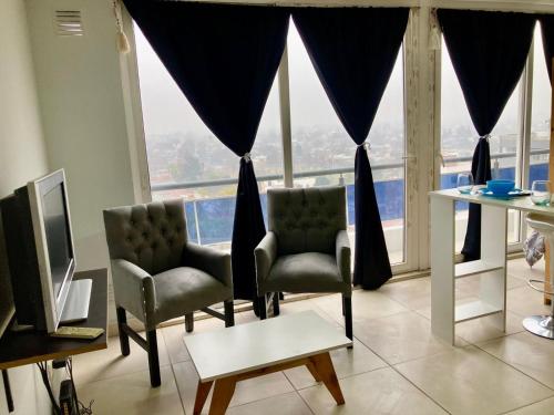 sala de estar con 2 sillas y ventana grande en 7-Exclusivo monoambiente en Moron centro, en Morón