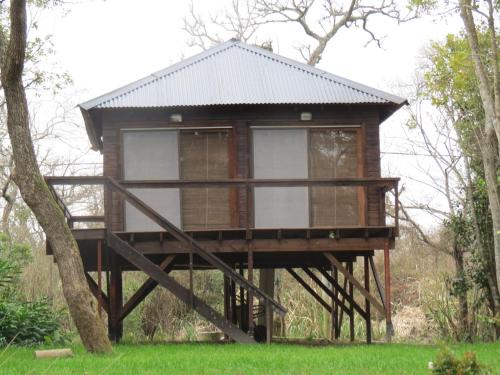 a tree house on a stand in the grass at La Tolerancia in Tigre