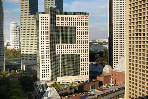 um edifício branco alto com uma letra x sobre ele em Conrad Centennial Singapore em Singapura