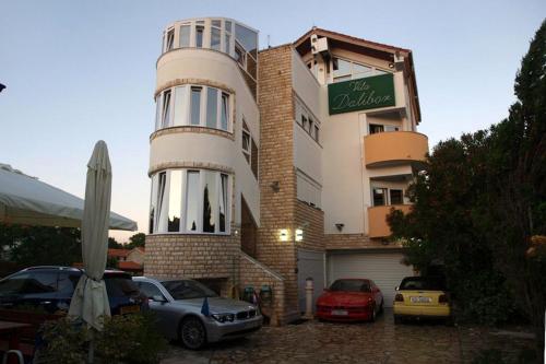 een gebouw waar auto's voor geparkeerd staan bij Apartments and rooms by the sea Nin, Zadar - 5858 in Nin