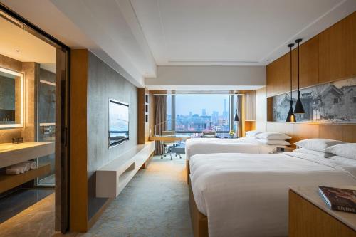 Cette chambre d'hôtel comprend deux lits et offre une vue sur la ville. dans l'établissement Renaissance Beijing Wangfujing Hotel, à Pékin