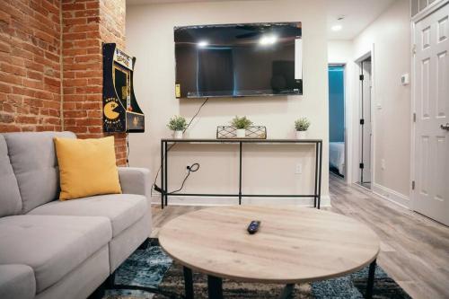 een woonkamer met een bank en een tafel bij Sleek and Cozy Micro Fells Point Residence! in Baltimore