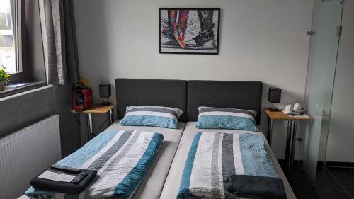 a bedroom with a bed with two pillows on it at Business-Motel, free XL-Parking, WiFi, massage-chairs, sauna, shared kitchen, breakfast 2go, free soda, coffee in Heimsheim