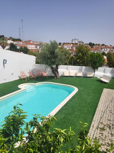 una piscina in un cortile con prato verde di Solar de Arrayollos Charming House ad Arraiolos