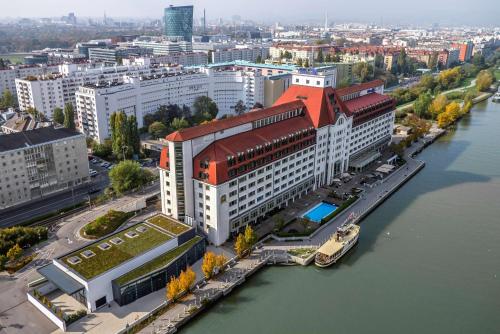 Hilton Vienna Waterfront في فيينا: اطلالة جوية على مدينة بها نهر ومباني