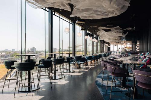 een rij tafels en stoelen in een kamer met ramen bij DoubleTree by Hilton Amsterdam Centraal Station in Amsterdam